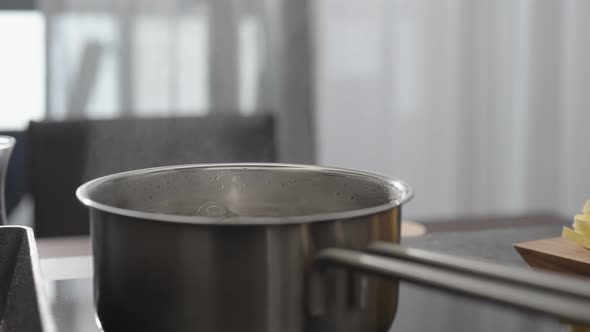 Slow Motion Gimbal Shot of Water Boil on Saucepan on Kitchen Stove with Back Light