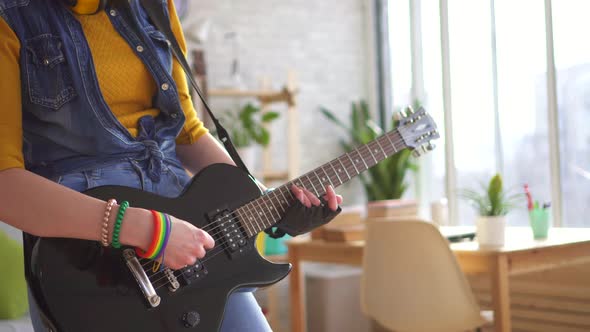 Close Up of Young Woman Rocker Playing Electric Guitar in Modern Apartment