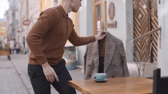 man in a cafe gets up from his chair and picks up his coat. Slow motion