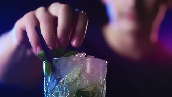 Male Bartender Puts Mint Leaves on Cocktails Then Flexes Arms