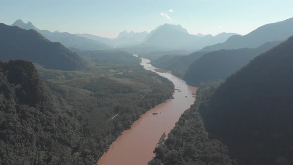 Aerial: flying over Nam Ou River Nong Khiaw Muang Ngoi Laos, sunset dramatic sky