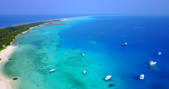 Luxury above clean view of a white sandy paradise beach and aqua blue ocean background in vibrant 4K