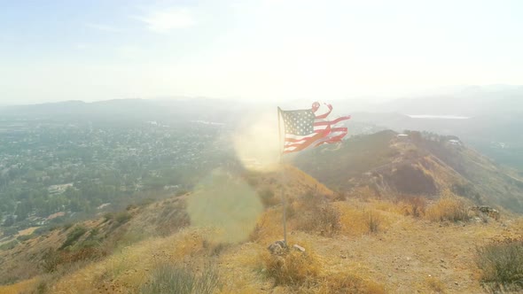 Inspirational Flight Around the American Flag Waving in Slow Motion on the Top of the Dry Hill