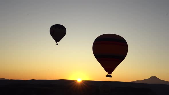 2 hot air balloons at sunrise in Cappadocia, Turkey seen from another ballon