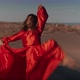 An Asian Woman in a Red Dress Dancing on Sand Dunes - VideoHive Item for Sale