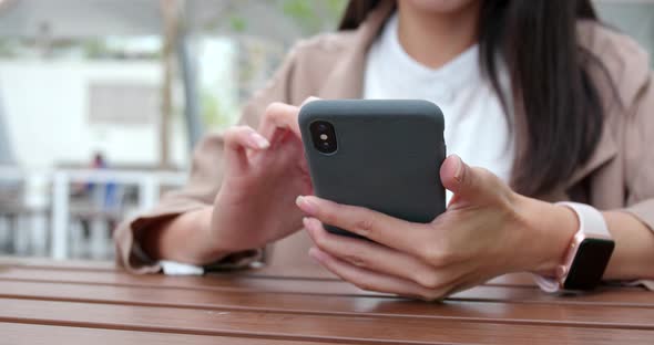 Woman using mobile phone at coffee shop