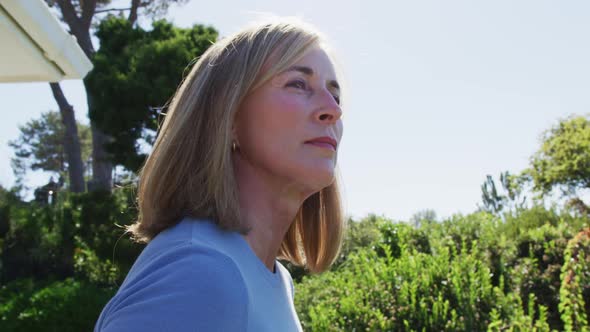 Portrait of senior caucasian woman smiling in a sunny garden