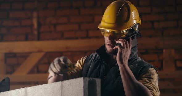 Man Answering Phone Call on Construction Site