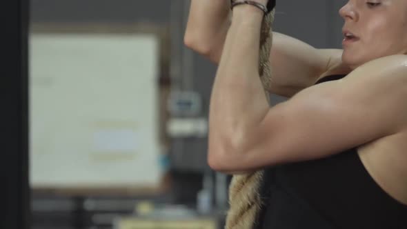 Beautiful Girl Athlete Climbs the Rope in Gym