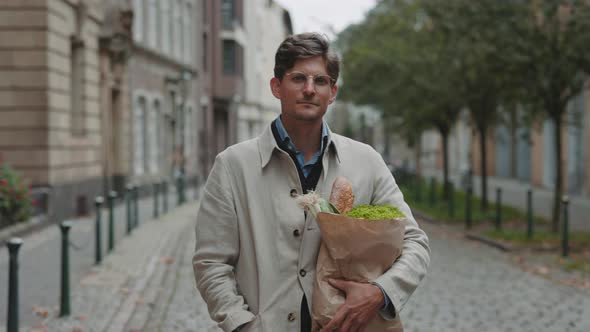 Businessman Standing on Street and Holding Grocery Bag