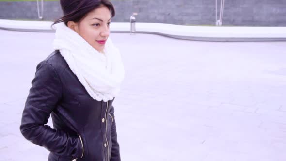 Young Brunette Woman in Scarf Walks in the Ciy