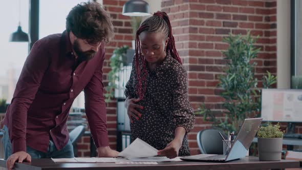 Woman Expecting Baby and Working on Business Project with Colleague