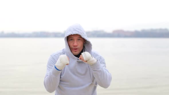 Boxing a man with an invisible opponent. A young man trains outdoors.