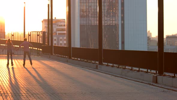 Couple Is Rollerblading at Sunset.