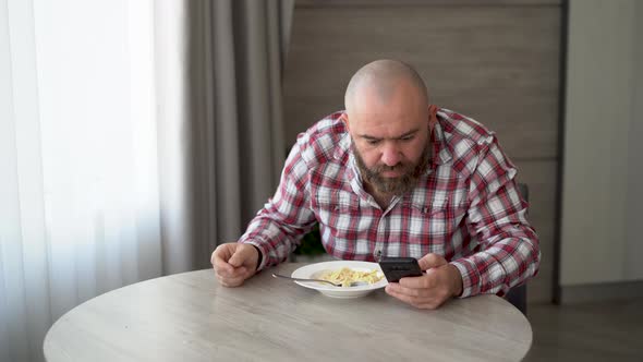 Bearded Man Having Breakfast at Home in Milk and Cereal