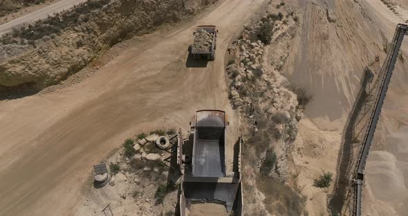 Quarry during work hours with Stone sorting conveyor belts and an open pit mine.