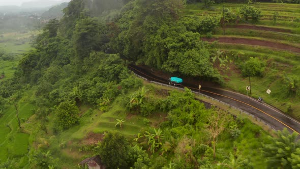 Aerial View of a Truck Driving on the Hill Road Past Farm Fields in Rural Countryside in Bali