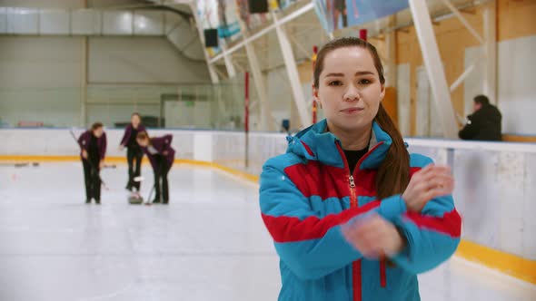 Curling Training - the Judge in Blue Jacket Standing on the Ice Rink Looking in the Camera - Her