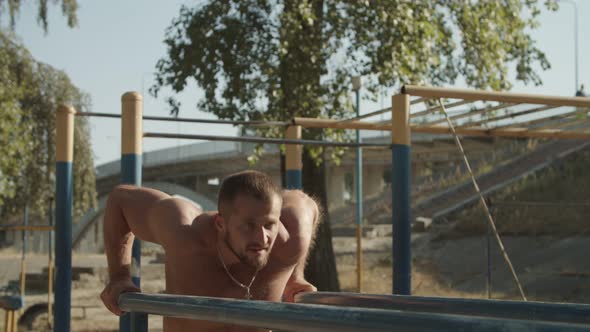 Fit Man Working Out Arms on Dips Horizontal Bars