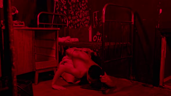 Crazy Half Naked Man Crawling Under the Bed in Red Lighting