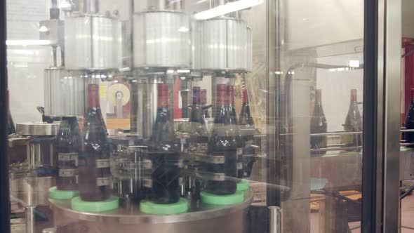 Red Wine bottles on a conveyor belt in a wine bottling factory.