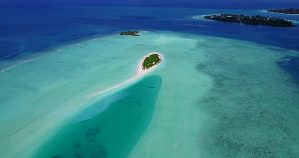 Daytime flying copy space shot of a white paradise beach and aqua turquoise water background in 4K