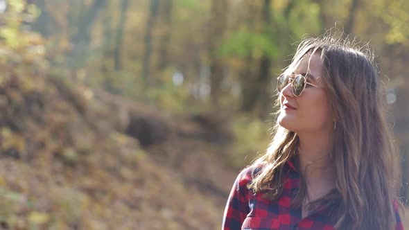 Girl walking in the woods with a bag on her back, girl in a red shirt