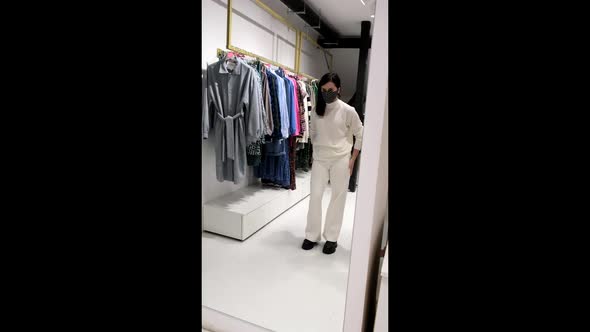 Woman Choosing Clothes in the Mall Store