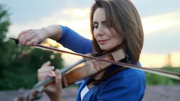 Adult Woman Violinist Playing Violin on Summer Lavender Field in Evening Closeup