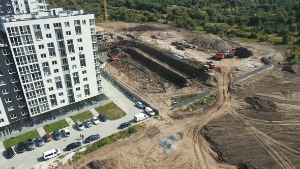 Aerial Shot Heavy Machinery Digs a Pit for the Future Home