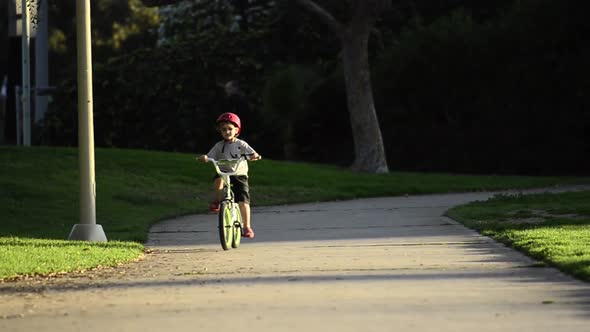 A boy riding a bike in a park.