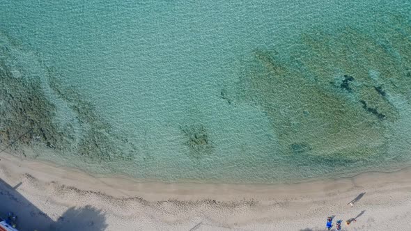 Aerial still shot of a sandy beach. Small wave motion