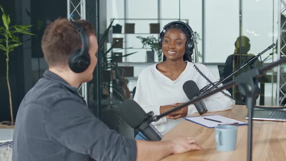 Female Host Talking to a Guest Friend on a Podcast Radio Station in the Studio