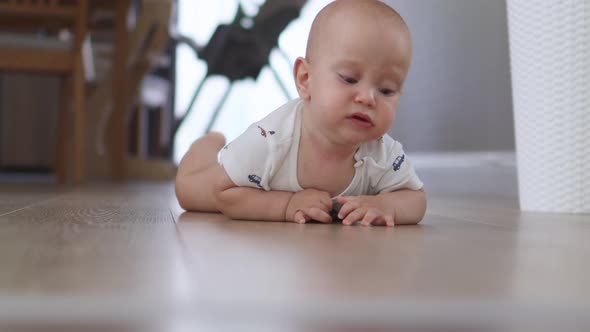 Crawling Infant Baby Lying on Floor Indoors Learning Crawl to Camera Emotions