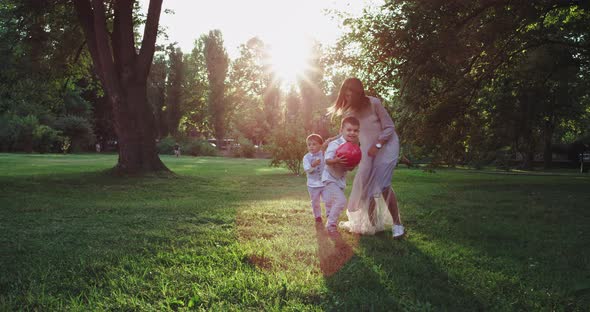 Running Happy Young Mommy and Her Cute Two Small