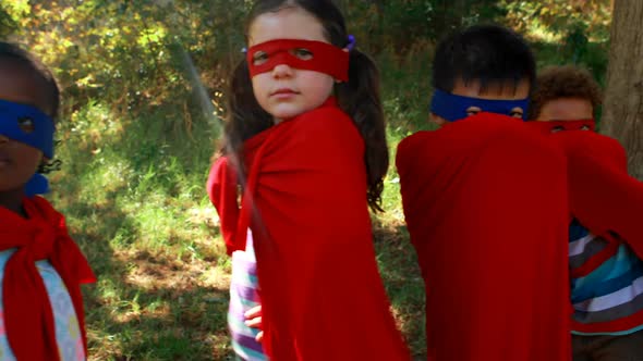 Friends pretending to be a superhero in park