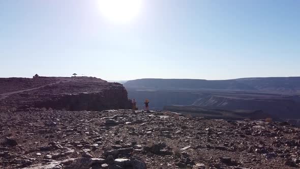 Massive canyon on the background of two people standing on the edge