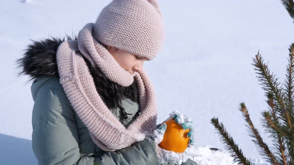 Girl with Mandarin By Fir Tree