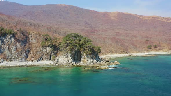 Aerial View of the Rocky Seashore of a Beautiful Bay with Transparent Water