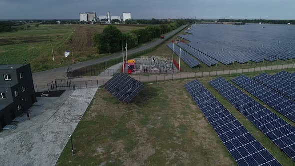 Aerial View of a Solar Power Station and Its Transformer on the Edge of Field