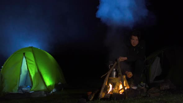 Campfire and camping tent at night.