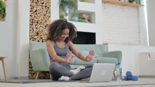 Young African Woman Talking on Video Call on Laptop While on Yoga Mat