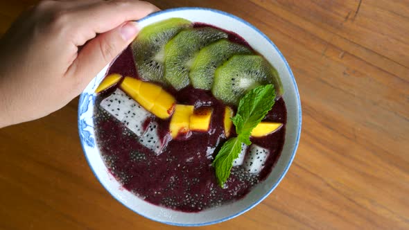 Woman Hand Rotate Vegan Smoothie Bowl with Fresh Fruits Healthy Breakfast