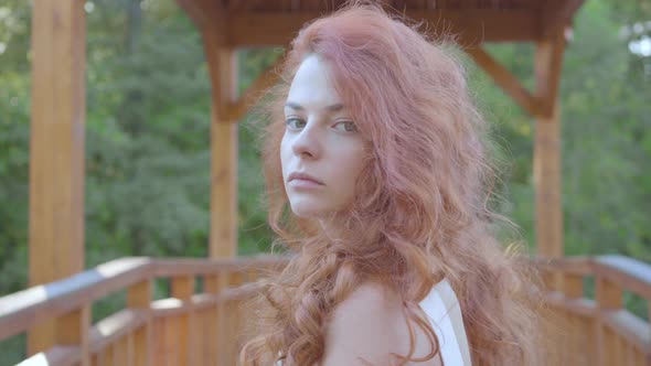 Incredibly Beautiful Caucasian Woman with Red Hair Turning Around and Looking at the Camera. Natural