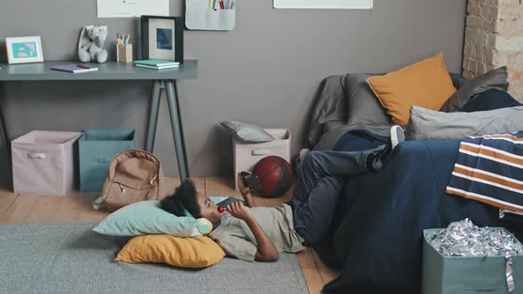 Boy Using Smartphone on floor in his Room