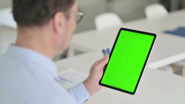 Middle Aged Man Using Tablet with Green Chroma Screen