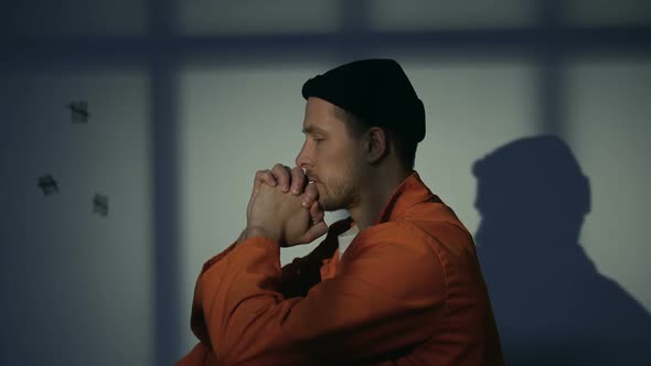 Innocent Male Prisoner Praying Asking for Mercy and Freedom, Turning to God