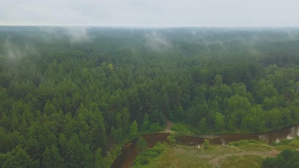 Distant Newlywed Couple Near Winding River By Green Forest