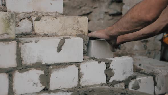 Construction Worker or Mason Laying Bricks and Creating Walls. Bricklayer Laying Bricks To Make a