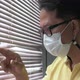 Slow-motion footage A man wearing a medical mask looks out of the window during a home quarantine. - VideoHive Item for Sale